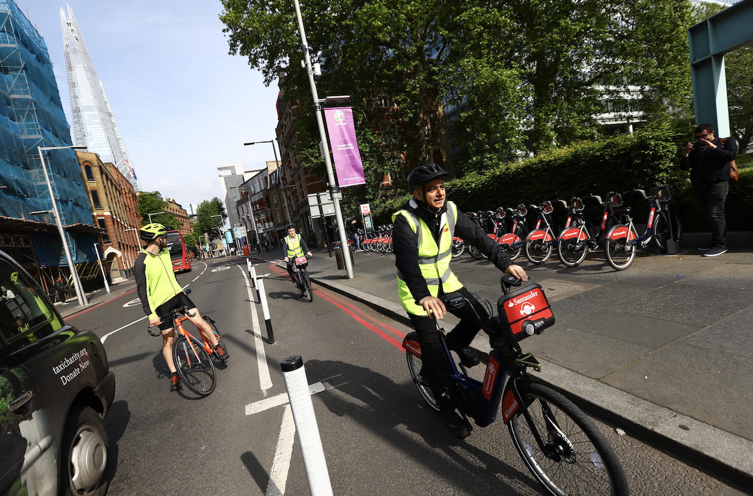 The Mayor of London cycling along the new temporary cycle lane on Tooley Street with Nathan Bostock, Santander UK