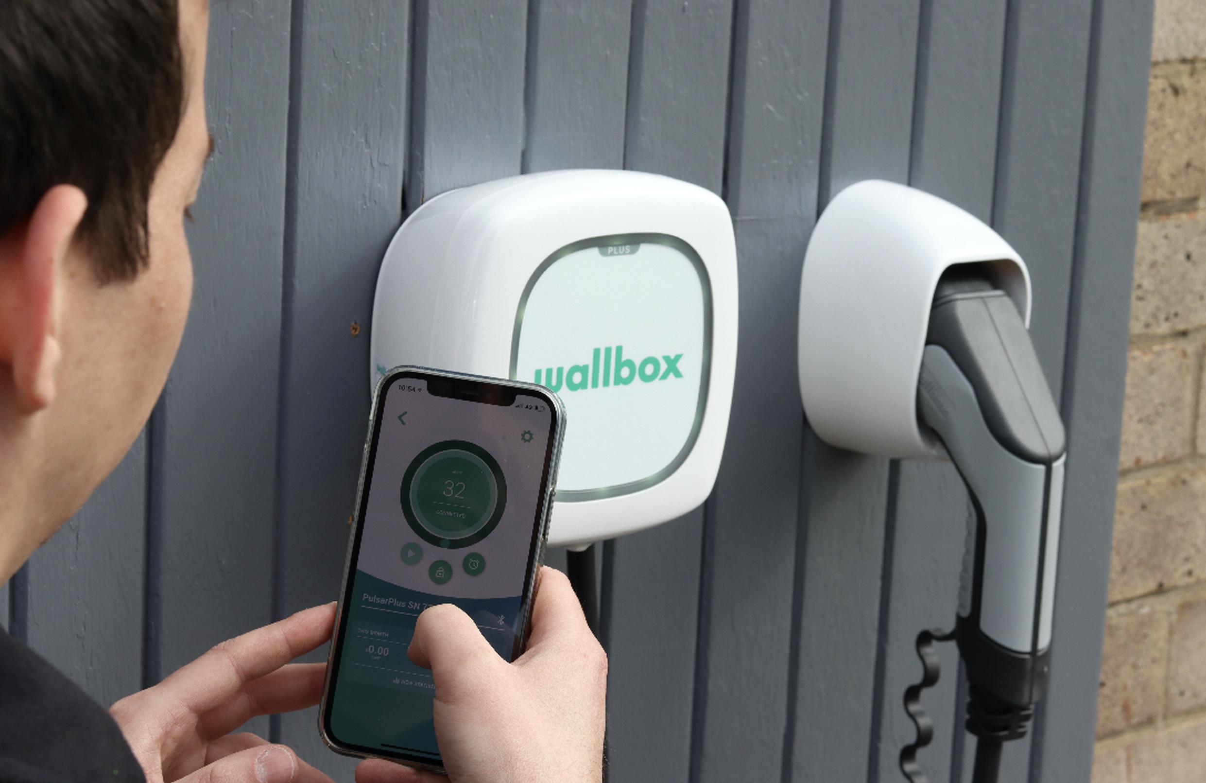 Smart Home Charger engineer pairs a wallbox with a customer`s smartphone