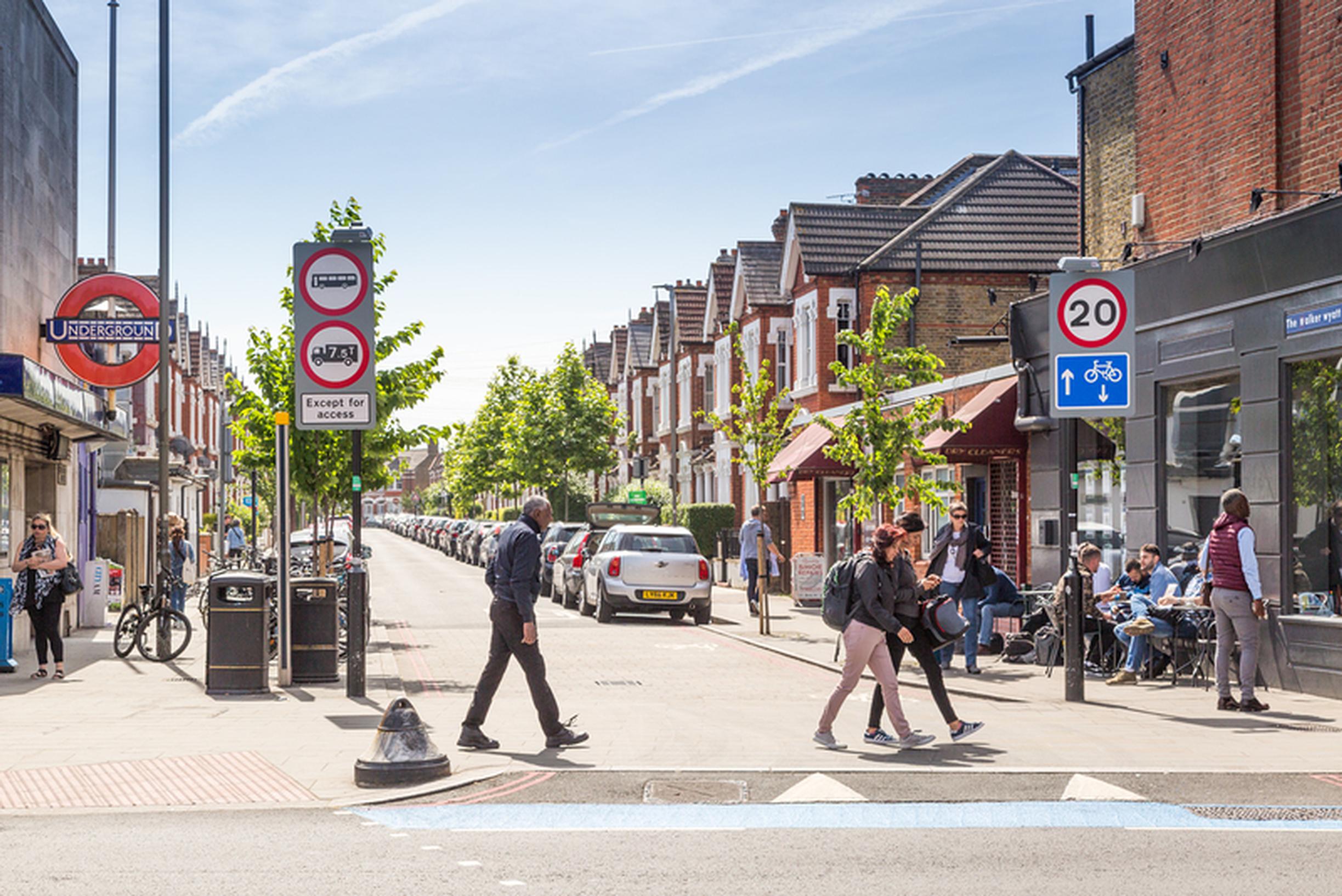 Pedestrians crossing the road outside Tooting Bec station