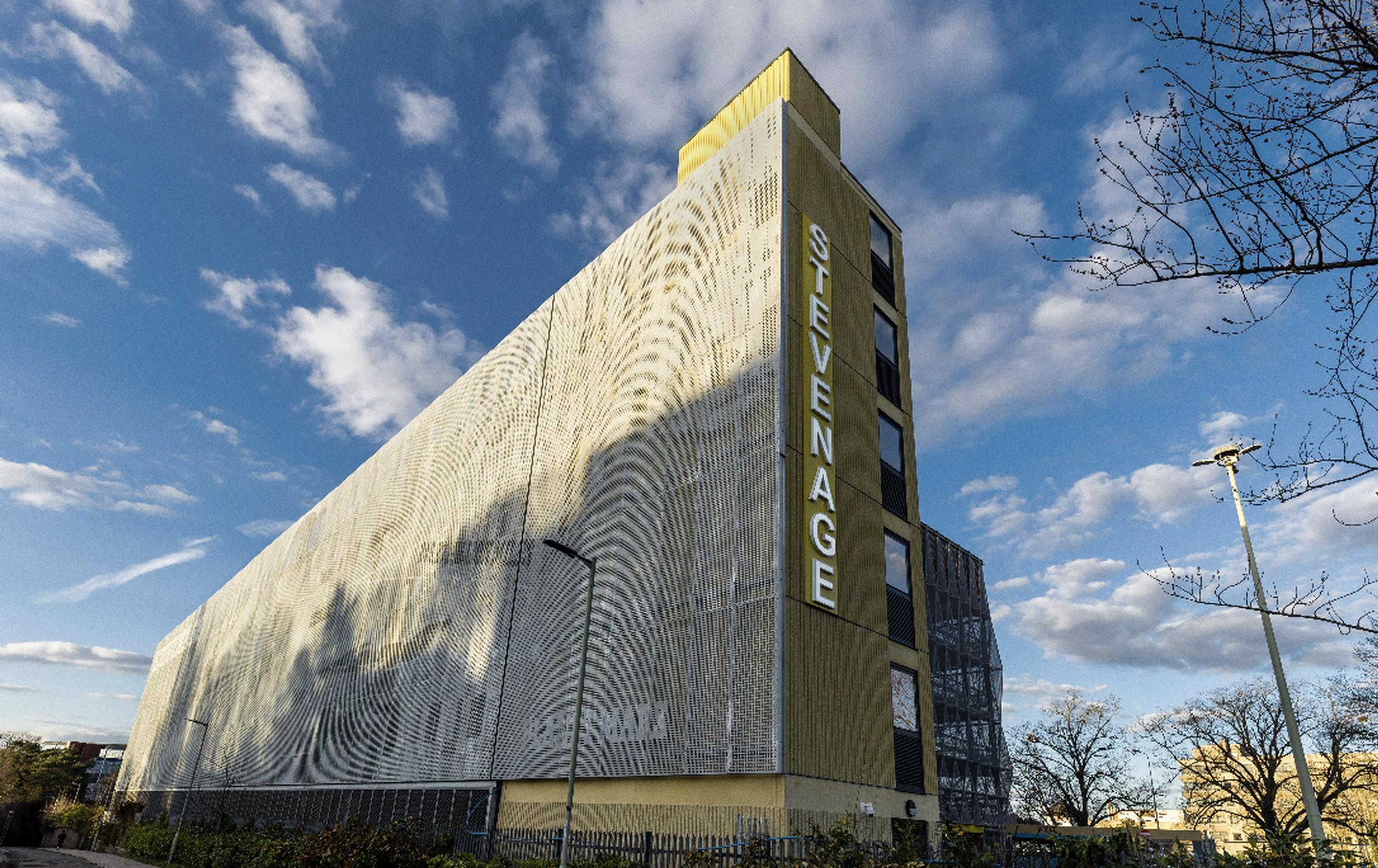 Stevenage Borough Council’s new multi-storey car park has been built by HUBER Car Park Systems to serve the Hertfordshire new town’s railway station. The car park features electric vehicle chargepoints and makes provision for cycle parking. The railway-facing west elevation of the car park features a montage of space exploration and scientific images, referencing Stevenage’s pioneering work in these sectors, whilst the town-facing east elevation features a range of human silhouettes and the town’s motto: “The heart of a town lies in its people.”