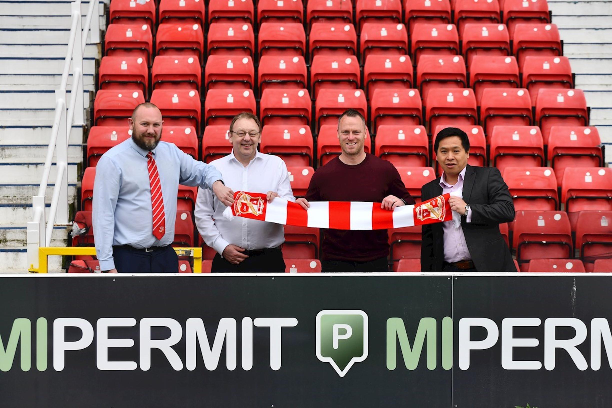Swindon Town FC’s commercial manager James Watts and manager Michael Flynn flank Chipside’s Paul Moorby OBE and Simon Cheung