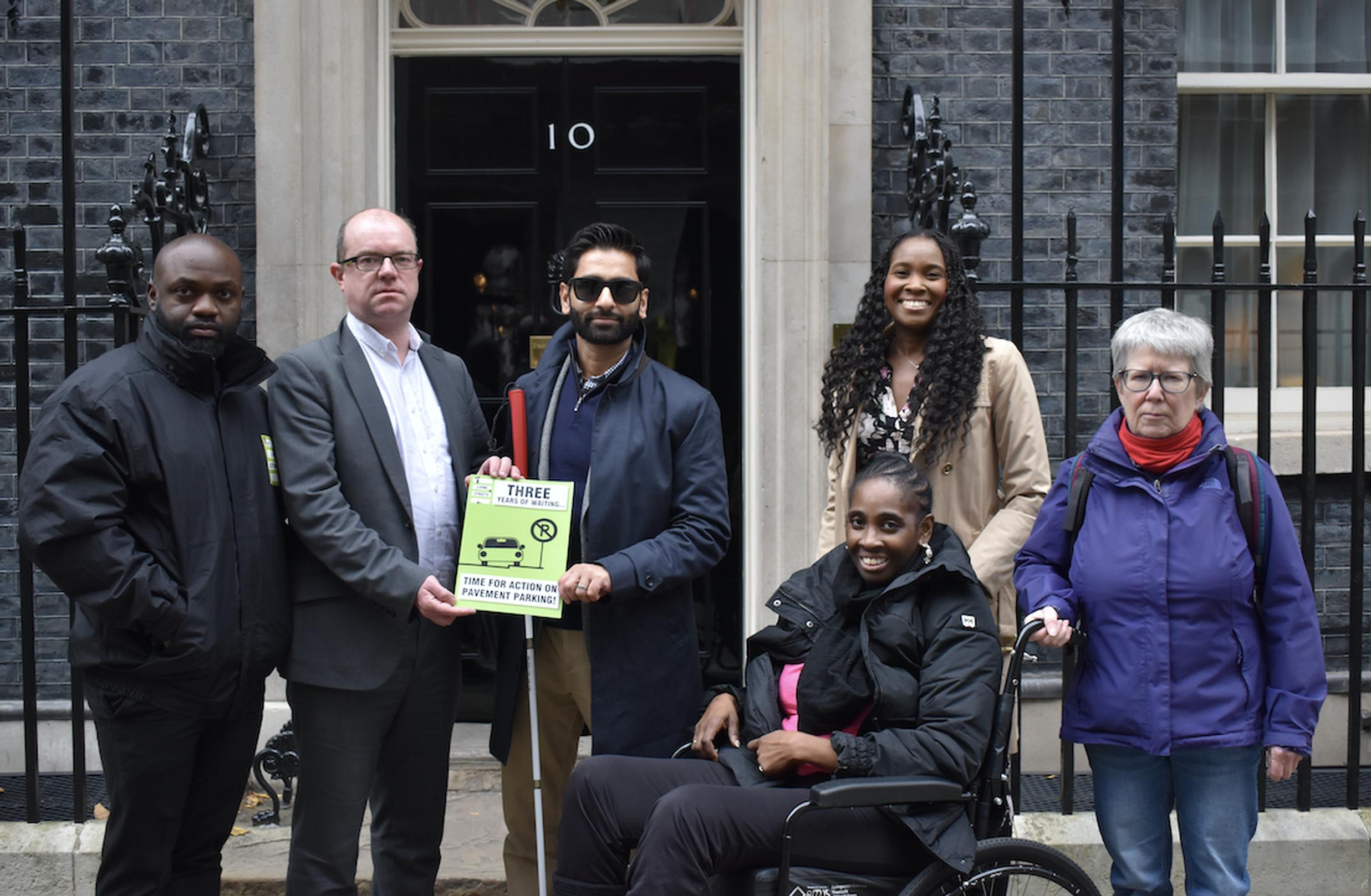 Living Streets representatives at 10 Downing Street with pavement parking ‘anniversary card’. (L-R) Bolaji Ogunsola (Living Streets Dagenham Over 65s Local Group), Stephen Edwards (chief executive, Living Streets), Dr Amit Patel (disability campaigner and Living Streets’ trustee), Patricia Edeam (Living Streets’ project coordinator), Catherine Edeam and Susie Morrow (Living Streets Wandsworth Local Group).
