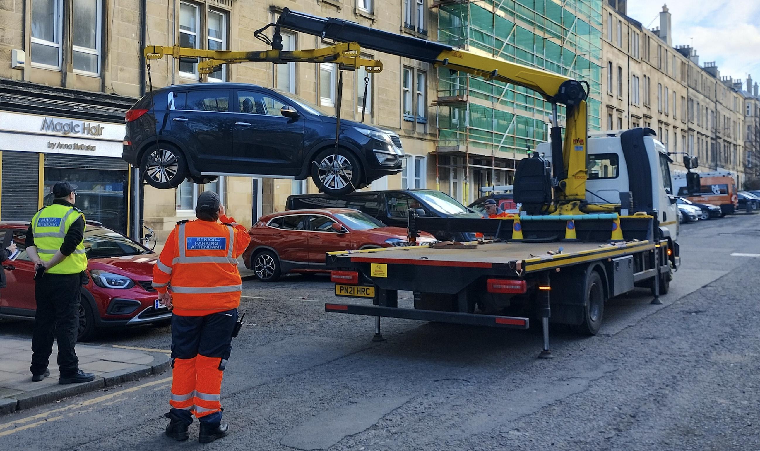 A vehicle being lifted for impoundment in Brunswick Street